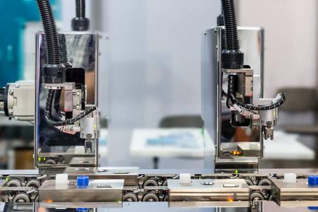 在工厂工作的人自动机器人手臂与光学传感器在工厂工作照片